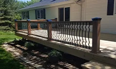 Side view of wood deck with curved black metal spindles, Omaha deck installation