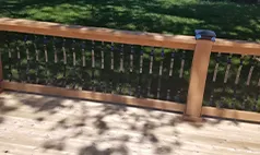 Close-up of wood deck railing with black spindles, Nebraska custom decking detail