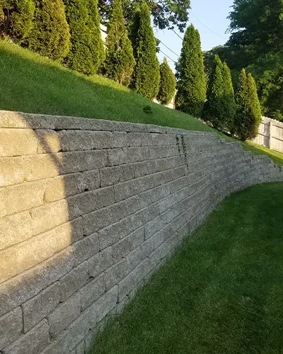 Finished retaining wall in Omaha providing slope stability and landscaping support by Liberty Contractors