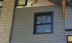 Gray vinyl siding installation on Omaha home with black window trim