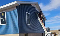 Contractor installing blue siding on a Papillion Nebraska house