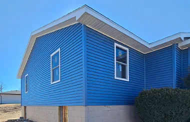 Completed storm damage restoration in Omaha showing full exterior with new siding, roofing, and insurance-covered rebuild.