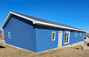 Omaha tornado rebuild with new blue siding and energy-efficient windows installed by Liberty Contractors.