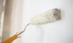 Interior wall painting Omaha with roller applying smooth coat of paint