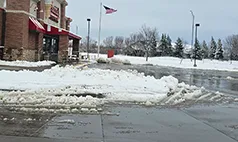 Commercial snow removal Omaha – cleared restaurant parking lot with snow plowed to the side