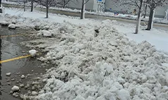 Omaha snow plowing service – snow piled safely in commercial parking lot after clearing