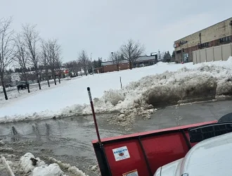 Professional snow plow Omaha – Liberty Contractors clearing commercial lot with plow truck