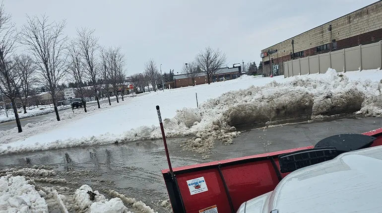 Professional snow plow Omaha – Liberty Contractors clearing commercial lot with plow truck