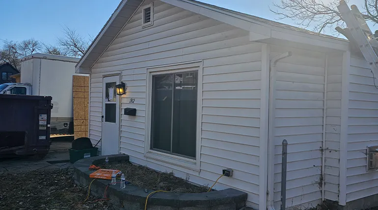 Before window and door installation in Omaha home showing unfinished siding and construction prep.