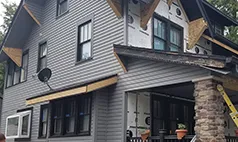 Omaha home with new windows installed during siding renovation project by Liberty Contractors.