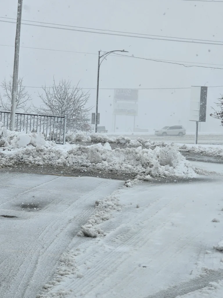 Snow removal service clearing heavy road slush during an Omaha winter storm.